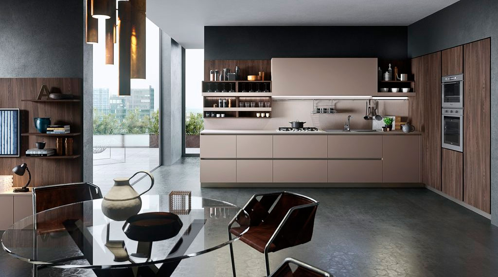 Cocina moderna de diseño con muebles en tonos neutros y madera, integrada a un espacio abierto con comedor y grandes ventanales.
