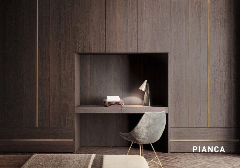 Escritorio integrado en armario de madera oscura con nicho iluminado, lámpara de mesa, máquina de escribir decorativa y silla tapizada en un ambiente minimalista y elegante