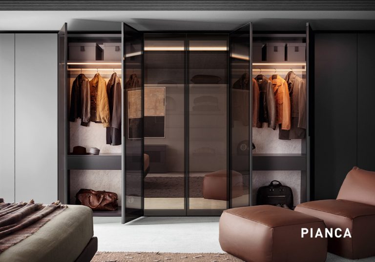 Vestidor moderno con armario abierto e iluminación integrada, puertas de vidrio ahumado, ropa colgada organizada y banco tapizado en primer plano